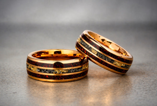 Two gold rings with embedded stones on a gray surface